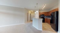 This single-level residence in Dunwoody, Georgia offers a well-designed open-concept layout that seamlessly connects the kitchen, dining, and living areas. The kitchen is a standout feature, showcasing warm medium-toned wood cabinetry, granite countertops, a slate-blue subway tile backsplash, and black appliances including a range, over-the-range microwave, dishwasher, and refrigerator. A peninsula with pendant lighting serves as a functional divide between the kitchen and living space, which is finished with plush carpeting and crown molding. The living area benefits from a ceiling fan and French doors that open to a balcony, inviting natural light and outdoor views.

The bedrooms are carpeted and generously proportioned, each with windows that provide natural light. At least one bedroom is accompanied by a walk-in closet with multi-level wire shelving systems offering ample organization. The bathrooms are finished with tile flooring, dark wood vanities, white countertops, and tub-shower combinations. Throughout the unit, neutral tones create a cohesive, move-in-ready atmosphere suited for comfortable everyday living.