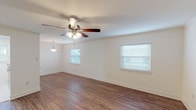 This single-floor residence features 2 bedrooms and 2 bathrooms within a thoughtfully arranged floor plan. The main living area is bright and welcoming, finished with durable hardwood-style flooring and crisp white walls that create a clean, airy atmosphere. Multiple windows fitted with blinds allow natural light to filter throughout, while ceiling fans with integrated lighting provide both comfort and illumination. A pendant light fixture adds a decorative touch to the dining area adjacent to the living space.

The kitchen is well-appointed with white shaker-style cabinetry, granite-look countertops, a stainless steel double-basin sink, and a built-in dishwasher. A window above the counter brings in additional natural light, making the space feel open and functional.

Both bedrooms are carpeted for warmth and comfort, each equipped with a ceiling fan and window. The bedrooms offer closet storage, including a bifold-door closet with built-in shelving and hanging rods. The bathrooms are finished with marble-style tile flooring and tub surrounds, white vanities with drawers, and chrome fixtures, presenting a clean and updated aesthetic throughout. The overall design is neutral and move-in ready.