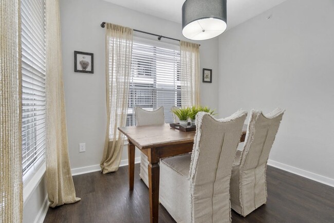 Platinum White Scheme - Dining Area with Wood Style Flooring and Expansive Windows with Natural Light - Flatiron District at Austin Ranch