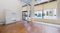 Located in the heart of downtown Tulsa at 6 E 5th St, this two-floor residence offers a generous and well-appointed layout spread across two distinct levels. The main floor commands an expansive footprint, anchored by a dramatic living area with soaring ceilings and oversized street-facing windows that flood the space with natural light and offer direct views of the urban streetscape. A built-in window seat adds a distinctive architectural touch, while warm hardwood flooring runs throughout.

The kitchen is fully equipped with stainless steel appliances, including a range, dishwasher, and a large French door refrigerator. Two-toned cabinetry — dark lower cabinets paired with white uppers — frames a herringbone tile backsplash and sleek quartz countertops, creating a polished, contemporary aesthetic. The open layout connects the kitchen seamlessly to the living areas.

Three well-finished bathrooms are featured throughout the residence. The primary bath is particularly noteworthy, showcasing large-format marble-look tile, an open walk-in shower, white shaker cabinetry, grey quartz countertops, and gold-accented mirrors and fixtures. A dedicated laundry area with a stacked Whirlpool washer and dryer adds everyday convenience. The upper level provides additional living space, two closets, and a hallway connecting all areas cohesively.
