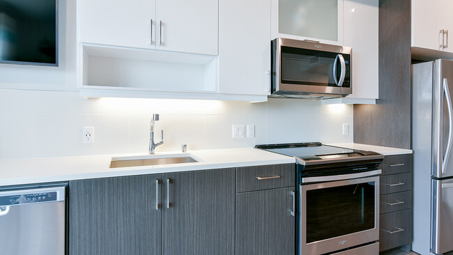 Kitchens feature tiled backsplash, USB ports, and under cabinet lighting - Modera San Pedro Square