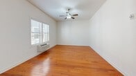 Located at 103 S Wood Ave in Linden, NJ, this one-bedroom, one-bathroom residence offers a well-organized layout across a single floor. Warm hardwood flooring flows throughout the living areas and bedroom, creating a cohesive and inviting atmosphere.

The open-concept kitchen and living area serves as the heart of the home. The kitchen is equipped with granite countertops, a peninsula with an undermount stainless steel sink, black appliances including a refrigerator, range, and built-in microwave, complemented by gray cabinetry with tile backsplash accents. Track lighting overhead adds a modern touch, while a large window allows natural light to fill the space.

The living room extends seamlessly from the kitchen, featuring a ceiling fan and wall-unit HVAC. Windows dressed with horizontal blinds bring in additional natural light and outdoor views.

The bedroom is a comfortable retreat with high ceilings, hardwood floors, a wall-unit HVAC, and a large window. A closet with paneled doors provides practical storage, and the room connects conveniently to the rest of the unit via a hallway.

The bathroom features large-format tile flooring, a tub/shower combination with tiled surround, a wall-mounted storage cabinet in warm wood tones, and accessibility grab bars for added convenience.