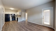 This well-appointed one-bedroom, one-bathroom unit offers a practical and modern living experience across a single floor. The open-concept layout seamlessly connects the living area to the kitchen, creating a sense of spaciousness. Rich, dark hardwood-style flooring runs throughout, providing a warm and cohesive aesthetic.

The kitchen is a standout feature, boasting crisp white shaker cabinetry, light quartz countertops, and a classic grey subway tile backsplash. A full suite of black appliances — including a refrigerator, electric range, microwave, and dishwasher — provides everything needed for daily living. A stainless undermount sink completes the space.

The bedroom is a comfortable retreat, featuring a ceiling fan, a closet, and a window with blinds that allow for natural light. Neutral-toned walls throughout the unit create a calm and versatile backdrop.

The bathroom is finished with large-format tile surrounding the tub-shower combination, a white vanity with modern hardware, and tile flooring. Additional highlights include a dedicated closet and a private patio, offering a touch of outdoor space. The unit's neutral palette and consistent flooring tie the entire space together for a clean, move-in-ready feel.