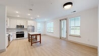 Located at 5025 Huntly Ridge St in Charlottesville, VA, this well-appointed 2-bedroom, 2-bathroom residence offers a clean, modern design across a single thoughtfully arranged floor. The open-concept living and kitchen area is bright and welcoming, with light wood-style flooring, white walls, and multiple windows fitted with blinds that invite natural light and frame views of the surrounding neighborhood and greenery. A glass door provides direct access to the outdoors, further enhancing the sense of openness.

The kitchen is equipped with stainless steel appliances — including a refrigerator, range, over-the-range microwave, and dishwasher — complemented by crisp white cabinetry with matte black hardware, white countertops, and a tile backsplash. A center island adds additional prep and dining space.

Both bedrooms feature plush carpeting and ceiling fans, with windows offering pleasant outdoor views. The primary bedroom connects to a well-designed en-suite bathroom featuring a double-sink vanity with white countertops, a glass-enclosed shower, and light wood flooring. The second bathroom includes a full tub-shower combination and matching white finishes. Three closets provide ample storage throughout the residence, rounding out this move-in-ready home.