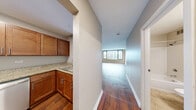 Located at 420 East Ohio Street in Chicago's vibrant Streeterville neighborhood, this well-designed unit offers a functional and comfortable single-floor layout comprising a combined kitchen and living area, a full bathroom, and a dedicated laundry room. The open living area is a standout feature, highlighted by rich hardwood flooring, neutral-toned walls, and a large bank of floor-to-ceiling windows that flood the space with natural light while framing impressive views of the Chicago skyline. The kitchen is outfitted with warm wood cabinetry, granite countertops, and stainless steel appliances including a refrigerator, electric range, and built-in microwave, offering both style and practicality. The bathroom features a full soaking tub with a shower, white tile surround, and stone-look tile flooring, creating a clean and classic aesthetic. A dedicated laundry room provides added convenience with a stacked washer and dryer unit, shelving, and wall hooks for organization. Throughout the space, consistent hardwood flooring and a cohesive neutral color palette contribute to a bright, modern ambiance. The unit's location in Streeterville places it within close proximity to Lake Michigan, Michigan Avenue, and a wealth of dining, shopping, and transit options.