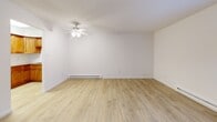This two-bedroom, one-bathroom residence in Bensalem, PA offers a practical and well-maintained single-floor layout. Light wood-look flooring runs consistently throughout the home, creating a cohesive and clean aesthetic in every room. The living room is a generously proportioned open space featuring a ceiling fan with light fixture and baseboard heating, providing year-round comfort. Natural light filters in through windows, keeping the area bright and welcoming. A front entry door with a sidelight window provides a straightforward point of entry, with a built-in closet nearby offering convenient storage. The kitchen is well-equipped with warm honey-toned wood cabinetry, granite-look countertops, a stainless steel sink, and white appliances including a range and over-the-range microwave. The primary bedroom is a comfortable, spacious room featuring a wall-mounted air conditioning unit and sliding glass doors that open to an outdoor area, allowing for natural light and ventilation. The second bedroom features a large window with natural light and baseboard heating. The bathroom is finished in white, complete with a tiled tub/shower combo, vanity with storage, and matching flooring. Throughout the home, the clean white walls and consistent flooring contribute to a bright, move-in-ready atmosphere.