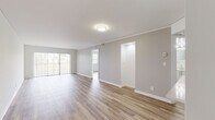 Located at 2831 N Course Dr in Pompano Beach, Florida, this single-floor unit offers a clean, modern aesthetic defined by a neutral color palette, crisp white trim, and wood-look flooring that runs consistently throughout every room. The open living and dining area is generously proportioned, with large sliding glass doors that invite abundant natural light and provide views of the surrounding landscape. Crown molding accents the living space, adding a refined architectural detail to the otherwise contemporary design.

A pass-through opening connects the living area to the kitchen, which is outfitted with sleek white cabinetry, quartz countertops, and a full suite of stainless steel appliances, including a refrigerator, electric range, built-in microwave, and dishwasher. The layout is functional and efficient, maximizing counter and storage space.

The bedrooms are well-sized, each featuring natural light from windows with outdoor views and ample closet space. The bathroom includes a full tub-shower combo with white tile surround, a quartz-topped vanity with modern hardware, and wood-look flooring. A dedicated hallway connects the private areas of the unit, maintaining a clear and organized flow throughout the space.