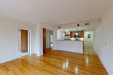 Located in Cambridge, MA, this 2-bedroom, 2-bathroom residence offers a thoughtfully designed single-floor layout that maximizes functionality and comfort. The open-concept living, dining, and kitchen area forms the heart of the home, where warm hardwood floors extend across the living and dining spaces, creating a bright and inviting atmosphere. Large windows allow natural light to flow in, with views of the surrounding neighborhood's mature, seasonal foliage.

The kitchen is well-equipped with stainless steel appliances, including a refrigerator, range, and built-in microwave, complemented by warm wood cabinetry and a granite countertop peninsula that doubles as a breakfast bar. Pendant lighting accents the space, adding a polished touch.

Both bedrooms are comfortably sized and feature built-in wood wardrobe cabinetry for ample storage. The primary bedroom is carpeted for warmth and is served by generous closet space. The second bedroom showcases hardwood flooring and large windows offering scenic outdoor views. Two full bathrooms serve the residence, one of which includes an in-unit laundry area. The bathrooms feature tile flooring, wood vanities, and a tub-shower combination. Overall, the space presents a clean, neutral palette with modern finishes throughout.