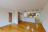 Located in Cambridge, MA, this 2-bedroom, 2-bathroom residence offers a thoughtfully designed single-floor layout that maximizes functionality and comfort. The open-concept living, dining, and kitchen area forms the heart of the home, where warm hardwood floors extend across the living and dining spaces, creating a bright and inviting atmosphere. Large windows allow natural light to flow in, with views of the surrounding neighborhood's mature, seasonal foliage.

The kitchen is well-equipped with stainless steel appliances, including a refrigerator, range, and built-in microwave, complemented by warm wood cabinetry and a granite countertop peninsula that doubles as a breakfast bar. Pendant lighting accents the space, adding a polished touch.

Both bedrooms are comfortably sized and feature built-in wood wardrobe cabinetry for ample storage. The primary bedroom is carpeted for warmth and is served by generous closet space. The second bedroom showcases hardwood flooring and large windows offering scenic outdoor views. Two full bathrooms serve the residence, one of which includes an in-unit laundry area. The bathrooms feature tile flooring, wood vanities, and a tub-shower combination. Overall, the space presents a clean, neutral palette with modern finishes throughout.