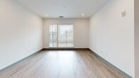 Located at Brooklyn Village in uptown Charlotte, NC, this one-bedroom, one-bathroom unit offers a well-designed single-level floor plan with modern finishes throughout. The open-concept kitchen and living area serves as the heart of the home, featuring gray shaker-style cabinetry, white quartz countertops, a subway tile backsplash, and a full suite of stainless steel appliances including a refrigerator with ice maker, electric range, and over-the-range microwave. A kitchen island with an undermount sink adds both functionality and style, while light wood-style flooring flows seamlessly through the main living areas. The living room benefits from recessed lighting, a ceiling fan, and large windows fitted with blinds that invite natural light. The bedroom is a comfortable retreat with plush carpeting, a ceiling fan, transom windows, and a sliding barn-style door that adds a contemporary touch. A dedicated closet provides in-unit washer and dryer hookups along with shelving for storage. The bathroom is finished with large-format tile, a soaking tub and shower combination, a white quartz vanity, and a stylish barn door entry. Clean lines and a neutral palette give the entire unit a bright, cohesive aesthetic.