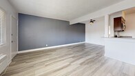 Located in Anaheim, CA, this well-appointed 1-bedroom, 1-bathroom unit offers a thoughtfully designed single-level layout with a clean, modern aesthetic throughout. Light wood-style plank flooring runs consistently across all living areas, complementing the crisp white walls and textured ceilings.

The open-concept living room is generously sized, featuring wide windows with horizontal blinds that invite ample natural light and a wall-mounted A/C unit for year-round comfort. A bold accent wall adds a touch of character to the space. The living area flows seamlessly into the kitchen via a peninsula with a dark countertop, ideal for casual dining or food prep.

The galley-style kitchen is efficiently designed with rich dark wood cabinetry, classic subway tile backsplash, dark countertops, and a full suite of stainless steel appliances including a gas range, microwave, and refrigerator.

The bedroom is a comfortable, well-lit retreat with a ceiling fan, a window for natural light, and light wood flooring that continues from the main living area. A dedicated closet provides convenient storage.

The bathroom features a clean, minimalist design with a full tub and shower surround clad in white tile, paired with white cabinetry and brushed nickel fixtures. The overall ambiance is bright, fresh, and move-in ready.