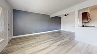 Located in Anaheim, CA, this well-appointed 1-bedroom, 1-bathroom unit offers a thoughtfully designed single-level layout with a clean, modern aesthetic throughout. Light wood-style plank flooring runs consistently across all living areas, complementing the crisp white walls and textured ceilings.

The open-concept living room is generously sized, featuring wide windows with horizontal blinds that invite ample natural light and a wall-mounted A/C unit for year-round comfort. A bold accent wall adds a touch of character to the space. The living area flows seamlessly into the kitchen via a peninsula with a dark countertop, ideal for casual dining or food prep.

The galley-style kitchen is efficiently designed with rich dark wood cabinetry, classic subway tile backsplash, dark countertops, and a full suite of stainless steel appliances including a gas range, microwave, and refrigerator.

The bedroom is a comfortable, well-lit retreat with a ceiling fan, a window for natural light, and light wood flooring that continues from the main living area. A dedicated closet provides convenient storage.

The bathroom features a clean, minimalist design with a full tub and shower surround clad in white tile, paired with white cabinetry and brushed nickel fixtures. The overall ambiance is bright, fresh, and move-in ready.