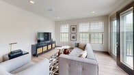 Located at 550 Futrall Dr in Fayetteville, AR, this well-appointed single-floor residence offers three bedrooms and four full bathrooms across a thoughtfully designed layout. Light wood-look flooring runs throughout, complementing a clean, contemporary aesthetic defined by white walls and recessed lighting.

The kitchen is a standout, featuring two-tone cabinetry — warm wood lower cabinets paired with crisp white uppers — dark granite countertops, stainless steel appliances, and a spacious island, all flowing seamlessly into the open living area. The living room benefits from an abundance of natural light through multiple large windows, offering views of the surrounding greenery.

Each bedroom is comfortably sized, with the primary bedroom showcasing a distinctive slatted wood accent wall that adds warmth and texture. All bedrooms feature light-filled windows. The four bathrooms are finished consistently with white vanities, backlit mirrors, and light flooring, providing a clean and functional design.

Outdoor living is well-supported by both a private enclosed patio with board-and-batten exterior siding — accessible via sliding glass doors — and a balcony overlooking the community, including a sports court and landscaped grounds. A dedicated closet rounds out the practical storage offerings of this modern Fayetteville residence.