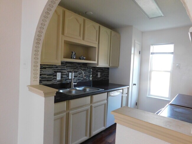 The new backsplash adds to the character of this charming home. The kitchen also includes very convenient amenities such as a stove, microwave, full-size refrigerator, and dishwasher. - 2216 Cimmaron Dr