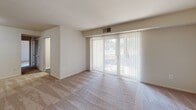Located at 4405 Bramblewood Ln in Henrico, Virginia, this single-floor residence offers a functional and comfortable layout across several well-defined spaces. The living area is generously sized, featuring neutral-toned carpeting and a large sliding glass door fitted with vertical blinds that allow abundant natural light while providing access to the outdoors. A secondary window in the living space further brightens the room with views of the surrounding greenery.

The kitchen is well-appointed with dark espresso cabinetry, granite-style countertops, and a full suite of black appliances including a gas range, dishwasher, and refrigerator. Wood-look flooring and a window above the sink add to the kitchen's practical appeal.

The bedrooms are carpeted and feature windows with blinds that frame outdoor views. One bedroom includes a ceiling fan and ample wall space, while another offers direct access to a spacious walk-in closet equipped with dual clothing rods and overhead lighting, providing generous storage capacity.

The bathroom features a dark-cabinet vanity with a white countertop and undermount sink, a large mirror with overhead lighting, and wood-look flooring, creating a clean and functional aesthetic throughout.