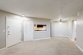 Located at 461 Greentree Ln in Milan, Michigan, this one-bedroom, two-bathroom unit offers a practical and efficiently designed single-floor layout. The open living room is generously proportioned for its footprint, featuring neutral-toned carpet, a textured ceiling, and a ceiling fan with light fixture. A pass-through window connects the living area to the kitchen, creating an open feel between the two spaces. The kitchen is equipped with dark cabinetry, white countertops, a stainless steel electric range, and wood-look vinyl flooring, providing a functional cooking environment. A closet with louvered bifold doors is conveniently located near the main entry. The bedroom offers a comfortable amount of space, carpeted flooring, a window with vertical blinds that allows natural light, and a dedicated closet. Two full bathrooms serve the unit — one featuring a white vanity with a mirrored medicine cabinet and wood-look flooring, and the other with a full tub-shower combo, wood-look flooring, and beadboard-style wainscoting. A hallway connects the private spaces of the unit. Throughout, the neutral color palette and consistent finishes give the space a clean, cohesive appearance.