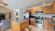 Located at 25 Silverlight Way in Rochester, NY, this two-bedroom, two-bathroom home spans two floors of thoughtfully arranged living space, complete with a garage and basement. The main floor features an open-concept layout combining the kitchen, dining room, and living room. The kitchen is well-appointed with warm wood cabinetry, stainless steel appliances including a French door refrigerator, electric range, and built-in microwave, all complemented by granite countertops and tile flooring. A breakfast bar adds casual seating, while track lighting keeps the space bright. The dining area enjoys abundant natural light through a large sliding glass door, accented by a classic chandelier overhead. The living room features hardwood flooring and vaulted ceilings, lending an open, airy feel. A welcoming entryway with tile flooring provides a practical transition space. Upstairs, the two bedrooms are carpeted and offer natural light through sizable windows. The bathrooms feature tile flooring, vanity storage, and tub/shower combinations. The attached garage provides generous vehicle and storage space with an automatic opener. A basement and utility room round out the home's functional layout, offering additional storage and utility access.