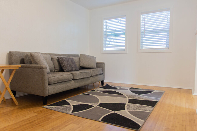 Living room with newly installed bamboo wood floors and lots of natural light. - 100 Beaver St