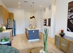 This 590-square-foot, one-bedroom, one-bathroom apartment at 4475 Scott Robinson Blvd, Unit 2125, Las Vegas, NV 89032, delivers a modern and efficient single-floor layout. The open-concept living room features light wood-style flooring, a ceiling fan, and a sliding glass door that opens to a private balcony with outdoor views — filling the space with natural light. The kitchen is outfitted with flat-front wood-toned cabinetry reaching to the ceiling, stainless steel appliances including a gas range, microwave, and refrigerator, a white quartz countertop, and a two-tone kitchen island with pendant lighting overhead. An in-unit stacked washer and dryer is conveniently tucked nearby. The 120-square-foot primary bedroom features large windows with outdoor views, neutral-toned accent walls, and plush carpeting. The full bathroom presents a clean, contemporary design with warm taupe walls, a floating wood vanity with an integrated sink, illuminated mirrors, and a full-size soaking tub with a tiled surround. A dedicated closet completes the unit, providing practical storage within this well-appointed Las Vegas apartment.