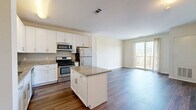 Located at 1 Glover Ave in Norwalk, Connecticut, this thoughtfully designed one-bedroom, one-bathroom residence offers a comfortable and modern living experience across a single floor. The open-concept kitchen and living area serves as the heart of the home, showcasing crisp white shaker cabinetry, granite countertops, a central island, and a full suite of stainless steel appliances including a range, microwave, and refrigerator. Rich hardwood-style flooring flows throughout the main living areas, adding warmth and continuity to the space. The living room is bathed in natural light and opens directly to a private balcony through sliding glass doors, offering pleasant outdoor views. The bedroom is a serene retreat featuring plush wall-to-wall carpeting, a large window with natural light, and a generously sized sliding-door closet providing ample storage. The full bathroom is finished with large-format tile flooring, a wide white vanity with under-cabinet storage, brushed nickel hardware, and a well-placed mirror. Clean neutral tones and consistent finishes throughout create a cohesive, move-in-ready aesthetic that is both functional and inviting.