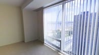 This single-floor space offers a clean, minimalist aesthetic defined by neutral tones, light-colored flooring, and smooth walls that create a bright and open atmosphere. The standout feature is the expansive floor-to-ceiling window wall fitted with vertical blinds, which frames a breathtaking, unobstructed view of the iconic Gateway Arch and the St. Louis riverfront skyline beyond. The elevated vantage point provides a sweeping panorama of the surrounding cityscape, including neighboring buildings and the Mississippi River in the distance, making the view a defining architectural centerpiece of the space. Natural light pours in generously throughout the day, illuminating the interior and enhancing the sense of openness and scale. The neutral palette of the walls and flooring keeps the focus on the remarkable outdoor scenery, while the understated design ensures versatility for a variety of uses. The recessed ceiling detail near the window adds subtle architectural interest, complementing the clean lines of the space. Overall, this property combines a simple, functional interior with an extraordinary urban outlook, making the panoramic view of one of America's most recognizable landmarks its most compelling and memorable attribute.
