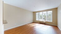 Located at 1425 NE Seventh Ave in Portland's vibrant Northeast neighborhood, this single-floor residence offers a well-designed layout with a cohesive, functional flow throughout. The open-concept living area is a standout feature, showcasing warm wood-look flooring that extends across the main living space. A large multi-pane window floods the room with natural light and frames a pleasant outdoor view of surrounding greenery, creating an inviting and airy atmosphere.

The kitchen is thoughtfully designed with light maple cabinetry, granite-look countertops, and stainless steel appliances including a refrigerator and microwave. A pass-through counter opening connects the kitchen to the living area, enhancing the open feel of the space. The kitchen area also features a built-in closet with shelving, providing generous storage.

The bedroom is finished with plush carpet and neutral warm-toned walls, offering a comfortable and quiet retreat. The full bathroom includes a soaking tub and shower combination, a single-sink vanity with matching maple cabinetry, and durable tile-look flooring. Throughout the unit, warm beige tones create a consistent, welcoming aesthetic that makes the space feel cohesive and move-in ready.