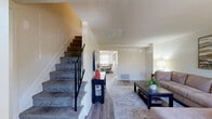 Located at 1833 Richfield Dr in Severn, Maryland, this two-floor home offers a well-organized layout across three bedrooms, one bathroom, and thoughtfully arranged shared spaces. The main level welcomes you with a bright living room featuring warm hardwood-style flooring, neutral walls, and a large window that draws in natural light. Adjacent to the living area is the kitchen, outfitted with warm wood cabinetry, white appliances including a gas range and dishwasher, and a dedicated dining nook with a window overlooking the exterior. The upper level hosts all three bedrooms. The spacious primary bedroom features hardwood-style floors, soft neutral tones, and ample room for a full furniture arrangement. The second bedroom offers carpeted flooring, a window with natural light, and wall-mounted television capability. The third bedroom is versatile, accommodating bunk beds and additional storage. The shared full bathroom includes a tub-shower combination with white tile surround, a wood vanity with white countertop, and tile flooring. Hallways connect each level efficiently, and a dedicated utility room and closet add functional storage. The home's clean, neutral palette and consistent finishes create a cohesive and livable atmosphere throughout.