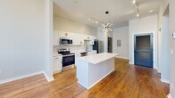 Located at 628 Madison Ave in Memphis, Tennessee, this 2-bedroom, 3-bathroom residence blends industrial character with modern finishes across a well-organized single-floor layout. Painted white brick walls and warm hardwood flooring run throughout, creating a cohesive aesthetic that balances raw texture with contemporary design.

The kitchen is a standout feature, offering white shaker cabinetry, a clean white countertop island, and a full suite of stainless steel appliances including a range, microwave, dishwasher, and refrigerator. A striking sputnik chandelier overhead adds a bold design accent to the open cooking and dining area.

Both bedrooms showcase the space's architectural character, with painted exposed brick walls, tall ceilings, and large windows that invite abundant natural light and outdoor views of the surrounding neighborhood. The primary bedroom features double dark-panel doors that lend a dramatic, intentional contrast to the lighter walls. Ceiling fans provide additional comfort in each room.

The three bathrooms are finished with white subway tile, matte black hardware and fixtures, and neutral tile flooring, offering a clean and modern feel. Each bathroom is thoughtfully appointed, with one featuring a tub-shower combination and another offering a walk-in shower with a white vanity. A hallway and closet complete the practical layout of this well-appointed Memphis residence.
