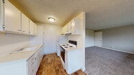Located at 922 North Pearl Street in Tacoma, Washington, this single-floor, 3-bedroom, 1-bathroom unit offers a practical and functional layout. The living area welcomes you with plush carpeting, neutral-toned walls, and large windows that invite natural light and outdoor views of the surrounding neighborhood. Baseboard heating is found throughout, ensuring year-round comfort.

The kitchen is efficiently designed with wood-look flooring, white cabinetry offering ample storage, white appliances including a coil-top range and refrigerator, and a built-in range hood. A pass-through counter connects the kitchen to the living space, creating an open, accessible flow.

The generously sized primary bedroom is a standout feature, offering substantial room for furnishings, carpeted flooring, a closet, and a window for natural light. The two additional bedrooms are well-proportioned, each with carpet, neutral walls, windows with outdoor views, and baseboard heaters. Two closets serve the unit's storage needs.

The full bathroom features a tub/shower combo, a window for ventilation, wood-look flooring, and a white vanity. Textured ceilings are consistent throughout the unit. The overall ambiance is clean, bright, and move-in ready.