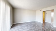 This single-floor apartment at 2248 Taft Circle in Winchester, Virginia offers a practical and well-organized layout. The living areas feature durable wood-look plank flooring in a neutral gray tone, complemented by textured ceilings and light gray walls throughout. A sliding glass door in the main living space allows natural light to pour in while providing outdoor access.

The kitchen is equipped with warm-toned oak cabinetry offering generous upper and lower storage, white laminate countertops, a double-basin stainless steel sink beneath a window, and a full suite of white appliances including a refrigerator, electric range, and dishwasher. A louvered pantry door provides additional storage nearby.

The bedrooms are finished with neutral carpet and feature clean white baseboards and trim. One bedroom includes a built-in closet with a rod and shelf, alongside a separate door connecting to additional spaces. The bathroom is outfitted with a white soaking tub and shower combination featuring chrome fixtures and a grab bar.

Overall, the unit presents a clean, neutral palette throughout, offering a functional and move-in ready living environment in Winchester, VA.