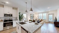 Located at 8251 Windsor Hill Blvd in North Charleston, SC, this single-floor residence offers a thoughtfully designed open-concept layout filled with natural light and contemporary finishes. The kitchen serves as the heart of the home, showcasing granite countertops, a large center island with pendant lighting, white shaker cabinetry with matte black hardware, subway tile backsplash, and stainless steel appliances. The island provides both ample prep space and casual seating, flowing seamlessly into the bright and airy living area. The living room features light hardwood-style flooring, recessed lighting, and generous windows that invite an abundance of natural light. A dedicated hallway connects the main living spaces to multiple bedrooms, each offering carpeted floors, ceiling fans, natural light from windows, and access to en-suite or adjacent bathrooms. The bathrooms are finished with clean white subway tile surrounds in the tub-shower combinations and light wood-style flooring, maintaining a crisp, cohesive aesthetic. An in-unit laundry area adds everyday convenience. Throughout, the home presents a neutral, warm palette with consistent design elements that create a welcoming and functional living environment.