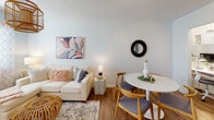 Located at 500 E Hargett St in the heart of Raleigh, NC, this single-floor residence offers a well-organized and thoughtfully designed layout. The living and dining area is warm and inviting, featuring wood-look flooring, soft neutral walls, and a natural rattan pendant light that adds a bohemian touch. A large window dressed with sheer patterned curtains brings in natural light, creating an airy atmosphere throughout. The dining space accommodates a round table with mid-century modern chairs, seamlessly blending with the living area's comfortable sectional sofa.

The kitchen is compact yet efficient, outfitted with butcher block countertops, white cabinetry, a herringbone tile backsplash, open wood shelving, and black appliances including a range and microwave, maximizing both style and functionality.

The bedroom is a calm retreat with soft blue-gray walls, wood-look flooring, and a bright window with horizontal blinds that allow natural light to filter in. Ample space accommodates a full dresser and generous bedside storage.

The bathroom features classic white subway tile surrounding a soaking tub and shower combination, a white vanity with chrome fixtures, a warm wood shelf, and a round mirror, completing the clean and cohesive aesthetic of the home.