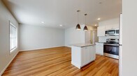 Located at 1344 New Britain Ave in West Hartford, CT, this single-floor unit offers a clean, modern aesthetic defined by warm hardwood flooring and a neutral color palette that flows seamlessly throughout the space. The open-concept layout connects the living area to a well-appointed kitchen, creating an inviting and functional gathering space. The kitchen is outfitted with crisp white shaker cabinetry, granite countertops, a white subway tile backsplash, and a full suite of stainless steel appliances including a range, microwave, dishwasher, and refrigerator. A central island with matching granite provides additional prep space and is accented by stylish pendant lighting above. Recessed lighting further brightens the open living and kitchen area. The unit includes multiple bedrooms, each featuring hardwood floors and windows that bring in natural light. Two full bathrooms are finished with white vanity cabinetry, granite countertops, and white subway tile. One bathroom features a tub-shower combination, while the second offers a walk-in shower. A dedicated entryway with a front door and adjacent window provides a welcoming arrival. The consistent finishes and thoughtful layout make this a comfortable and attractive space.