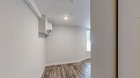 Located at 859 McCallie Ave in Chattanooga, Tennessee, this single-level studio offers a thoughtfully designed layout that maximizes every square foot of its compact footprint. The main living area features rich, wood-grain luxury vinyl plank flooring that runs throughout, complemented by crisp white walls and recessed lighting that keep the space feeling bright and open. A window allows natural light to filter in, adding warmth to the room's clean, neutral palette. A wall-mounted mini-split heating and cooling unit provides efficient, year-round climate control.

The kitchen is well-appointed with white shaker-style cabinetry extending to the upper walls, offering generous storage. Stainless steel appliances — including a gas range and over-the-range microwave — pair with light-toned countertops and a stainless sink to create a functional and attractive cooking space. The layout makes efficient use of an L-shaped counter configuration.

A dedicated open closet area with a hanging rod provides convenient clothing storage within the main living space. The full bathroom is finished in a clean, contemporary style, featuring large-format tile flooring, a walk-in shower/tub combination, a dark wood vanity with a white sink, and bright overhead lighting. The overall design of this space is modern, functional, and move-in ready.