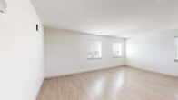 This single-floor residence offers a clean, contemporary design with a bright and airy ambiance throughout. The open living area features smooth light wood-toned flooring and crisp white walls, creating a neutral and versatile canvas. Multiple windows with horizontal blinds allow natural light to flow generously into the space, offering views of the surrounding neighborhood.

The kitchen is a functional highlight, showcasing modern flat-front cabinetry in a warm wood-grain finish paired with light quartz countertops and a white tile backsplash. Stainless steel appliances — including a range, over-the-range microwave, and dishwasher — are standard, complemented by an undermount sink with a brushed nickel faucet. Ample upper and lower cabinet storage adds practicality to the stylish design.

The bedrooms are finished with plush neutral carpeting, providing a comfortable and quiet retreat. Each room benefits from natural light via windows with views to the outdoors.

Two bathrooms mirror each other in design, each featuring wood-toned vanity cabinetry, light quartz countertops, an undermount sink, brushed nickel fixtures, and a full tub-shower combination. Light wood-look flooring ties the bathrooms together with the home's consistent modern aesthetic. The overall design is cohesive, clean, and move-in ready.