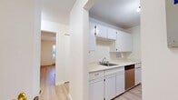 Located at 5830 Vedder Rd in Chilliwack, BC, this two-bedroom, one-bathroom unit is thoughtfully laid out across a single floor. Light wood laminate flooring runs throughout, creating a clean and cohesive look. The galley-style kitchen is well-equipped with white cabinetry, light countertops, stainless steel appliances including a refrigerator, electric range, and dishwasher, offering efficient use of space. The kitchen opens toward a hallway connecting the main living areas. The living room is bright and airy, featuring sliding glass doors that lead to a private balcony with outdoor views of surrounding greenery, allowing ample natural light to fill the space. Baseboard heating is present throughout. Both bedrooms are comfortably sized with large windows that frame views of the lush exterior, and the primary bedroom includes a built-in closet with dedicated shelving and hanging space. A connecting hallway provides easy access to all rooms. The bathroom features a full tiled tub-shower surround with classic white square tiles and chrome fixtures. Overall, the unit presents a clean, functional, and well-maintained living space in a residential Chilliwack neighbourhood.