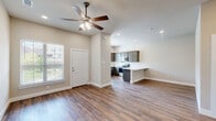 This two-story home offers 3 bedrooms and 4 bathrooms across a well-organized layout, with the main living areas situated on the ground floor and the bedrooms occupying the more spacious upper level. The ground floor features an open-concept kitchen and living room brightened by natural light from a large window, vaulted ceilings, and a ceiling fan. The kitchen is equipped with stainless steel appliances, gray shaker-style cabinetry, marble-look countertops, and a classic white subway tile backsplash, with a breakfast bar providing additional seating. Durable wood-look flooring flows throughout the main living areas, complementing the neutral, light-toned walls. The ground floor also includes an attached garage with an automatic opener, electrical panel, and water heater, as well as direct interior access. Upstairs, the spacious primary bedroom includes a walk-in closet and its own bathroom. Additional bedrooms are well-sized and serviced by the remaining bathrooms. A dedicated laundry room with washer and dryer hookups adds everyday convenience. Hallways connect the rooms efficiently, and two closets provide ample storage. The home's clean, modern aesthetic is carried consistently throughout with white panel doors, recessed lighting, and ceiling fans.