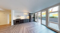 Located at 4035 Mercantile Dr in Lake Oswego, Oregon, this contemporary single-floor residence showcases a thoughtfully designed layout with modern finishes throughout. The standout kitchen is a chef's delight, featuring a striking two-tone cabinet design with crisp white upper cabinetry and deep charcoal lower cabinets, complemented by white quartz-style countertops and a classic subway tile backsplash. Premium stainless and matte black appliances — including a gas range, built-in microwave, dishwasher, and a large French door refrigerator — elevate the space further. Light-toned herringbone-pattern flooring adds a refined aesthetic detail underfoot. French doors in the kitchen open directly to an outdoor patio, flooding the space with natural light and providing seamless indoor-outdoor connectivity. The bedroom offers a wall-mounted mini-split system for personalized climate control and includes a built-in closet with adjustable shelving. Large windows in the living area invite generous natural light and offer views of the surrounding greenery. The bathroom is finished with a dual-sink dark wood vanity topped with a marble-look surface, stylish sconce lighting, and clean tile flooring. In-unit stacked Whirlpool washer and dryer complete this well-appointed home.