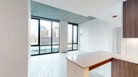 Located in the heart of Chicago's South Loop, this modern 2-bedroom, 3-bathroom residence at 626 South Wabash Avenue offers a sleek, contemporary design with high-end finishes throughout. Light wood flooring flows seamlessly across the entire unit, complemented by crisp white walls and exposed concrete ceilings that lend an urban industrial character.

The open-concept living room is anchored by dramatic floor-to-ceiling windows framed in matte black, flooding the space with natural light and offering sweeping views of the Chicago skyline. The kitchen is thoughtfully appointed with rich wood-toned cabinetry, quartz countertops, stainless steel appliances, a subway tile backsplash with under-cabinet lighting, and a peninsula that provides additional prep and seating space.

Both bedrooms are well-proportioned, with the primary bedroom featuring its own floor-to-ceiling window wall with city views and generous closet space. The three bathrooms maintain the unit's clean aesthetic with wood-finish vanities, white quartz countertops, and wood-look flooring. Hallways connect the rooms with an efficient, open layout. Two hallways provide organized circulation throughout the residence, making the overall flow intuitive and functional.