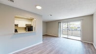 This 2-bedroom, 1-bathroom single-floor unit offers a well-organized layout that maximizes its compact footprint. The open-concept living area features light wood-look laminate flooring and a textured ceiling, creating a clean and cohesive aesthetic. Large sliding glass doors flood the living room with natural light and open directly onto a private balcony, offering pleasant outdoor views of the surrounding greenery and neighboring buildings.

The kitchen is accessed via a pass-through window opening to the living area, promoting an open and connected feel. It is equipped with white cabinetry, speckled countertops, a double stainless steel sink with a modern pull-down faucet, a dishwasher, and a stainless steel range. Light tile flooring completes the kitchen space.

The spacious primary bedroom features darker wood-look flooring, a window with natural views, and a generously sized closet with dual hanging rods for ample storage. The second bedroom shares a similar design language with matching flooring and neutral wall tones.

The bathroom is appointed with a full tub-shower combo featuring white subway tile surround, a white vanity with speckled countertop, and wood-look flooring that ties the space together. Throughout, neutral gray wall tones and consistent finishes create a cohesive, move-in-ready environment.