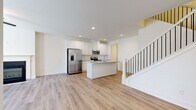 Located in Conyers, GA, this two-story home offers three bedrooms, three bathrooms, and a thoughtfully designed layout spread across two floors. The lower level hosts an open-concept kitchen and living area finished with light hardwood-style flooring throughout. The kitchen is outfitted with crisp white shaker cabinetry, granite countertops, a center island with an undermount sink, and a full suite of stainless steel appliances including a French door refrigerator, electric range, and microwave. The living room features a fireplace with a classic white surround, dual windows that bring in natural light, and a ceiling fan overhead. An attached garage with automatic opener and utility access completes the ground floor. Upstairs, the spacious primary bedroom includes a walk-in closet and an en-suite bathroom with both a soaking tub and a separate glass-enclosed shower, plus granite vanity countertops. Two additional bedrooms, each with light-filled interiors and closet space, share access to the remaining bathrooms. Hallways connect the upper-level rooms efficiently. Clean white walls, recessed lighting, and consistent flooring throughout lend the home a bright, cohesive aesthetic.