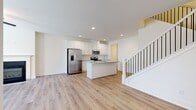 Located in Conyers, GA, this two-story home offers three bedrooms, three bathrooms, and a thoughtfully designed layout spread across two floors. The lower level hosts an open-concept kitchen and living area finished with light hardwood-style flooring throughout. The kitchen is outfitted with crisp white shaker cabinetry, granite countertops, a center island with an undermount sink, and a full suite of stainless steel appliances including a French door refrigerator, electric range, and microwave. The living room features a fireplace with a classic white surround, dual windows that bring in natural light, and a ceiling fan overhead. An attached garage with automatic opener and utility access completes the ground floor. Upstairs, the spacious primary bedroom includes a walk-in closet and an en-suite bathroom with both a soaking tub and a separate glass-enclosed shower, plus granite vanity countertops. Two additional bedrooms, each with light-filled interiors and closet space, share access to the remaining bathrooms. Hallways connect the upper-level rooms efficiently. Clean white walls, recessed lighting, and consistent flooring throughout lend the home a bright, cohesive aesthetic.