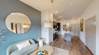Located at 1851 Knightsbridge Rd in Farmers Branch, TX, this thoughtfully designed one-bedroom, one-bathroom residence offers a cohesive open-concept layout that maximizes every square foot. Wood-look plank flooring flows throughout the main living areas, grounding the space with warmth and continuity.

The kitchen is a standout feature, showcasing rich dark espresso cabinetry reaching toward the ceiling, crisp white quartz countertops, a subway tile backsplash, and a full suite of stainless steel appliances including a refrigerator, range, microwave, and dishwasher. A central island with pendant lighting above adds both prep space and a natural gathering point that opens seamlessly to the living area.

The living space is anchored by a striking slate-blue accent wall, recessed lighting, and a ceiling fan, creating a relaxed yet polished ambiance. Natural light filters in through large windows, enhancing the bright, airy feel of the home.

The bedroom continues the blue accent wall motif, offering a calm, cohesive retreat with a large window overlooking the outdoors. It connects directly to the full bathroom, which features a dark-cabineted vanity with a white countertop, a soaking tub, and access to a spacious walk-in closet outfitted with multi-tier shelving and hanging rods.