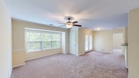 Located at 343 Sycamore Ln in South Lebanon, Ohio, this single-floor, 2-bedroom, 2-bathroom home offers a well-organized and comfortable layout. The spacious primary bedroom features plush carpeting, a ceiling fan with light fixture, a wide multi-pane window that fills the room with natural light, and elegant French doors that open to additional living space. A closet and clean white trim complete the room's polished look. The second bedroom is generously sized with soft carpeting, two windows offering views of lush greenery, and a built-in closet with a paneled door. Both bathrooms are equipped with soaking tub and shower combinations, surrounded by clean white tile surround with integrated shelving niches, offering a functional and relaxing experience. The dedicated laundry room houses the water heater, HVAC unit, and electrical panel, along with shelving and tile flooring for added practicality. Throughout the home, warm neutral wall tones, plush carpeting in the bedrooms, and consistent white trim create a cohesive and inviting atmosphere. The layout also includes a hallway and a closet, contributing to the home's efficient use of space. Natural light flows throughout, enhanced by the greenery visible through multiple windows.