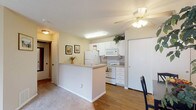 Located at 4140 Appian Way in Gahanna, Ohio, this single-floor residence offers a functional and comfortable layout designed for everyday living. The open-concept living area is bright and welcoming, featuring plush carpeting, neutral-toned walls, and a large sliding glass door that invites natural light and provides an outdoor view. French doors add a classic architectural touch, further enhancing the openness of the space.

The kitchen is efficiently designed with white cabinetry, white appliances including a refrigerator, electric range, and built-in microwave, and a peninsula counter that separates it from the living area. Wood-look flooring runs throughout the kitchen and dining areas, providing a warm contrast to the carpeted living space. A ceiling fan with a light fixture adds both practicality and comfort to the kitchen zone.

A dedicated dining area accommodates a compact dining table and chairs, making it ideal for casual meals. The space is conveniently positioned adjacent to the kitchen for a seamless flow.

The bathroom features a wide vanity with a single sink and solid-surface countertop, white cabinetry beneath, and a large mirror above. A shower-tub combination is visible in the background, completing this functional and tidy space.

Overall, this residence offers a cohesive, cozy ambiance with practical finishes throughout.
