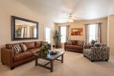 Located at 435 Ithaca Ct in Las Cruces, New Mexico, this single-story home offers a well-organized, comfortable layout designed for everyday living. The living room serves as the heart of the home, featuring plush carpeting, a ceiling fan with integrated lighting, multiple windows with blinds and curtain panels that invite abundant natural light, and a welcoming neutral color palette. A large decorative mirror adorns one wall, amplifying the sense of space throughout.

The galley-style kitchen is outfitted with warm honey-toned wood cabinetry, white appliances including a range and dishwasher, and durable tile flooring. An arched doorway adds an architectural touch, connecting the kitchen to the rest of the home. Adjacent to the kitchen, the dining area accommodates a full dining set and benefits from generous window coverage with linen-style drapes, creating a bright and inviting atmosphere for meals.

The bedrooms offer carpeted floors and ample natural light. One bedroom features a dramatic four-poster bed frame, while another showcases an ornate wrought iron headboard, both reflecting a warm, classic aesthetic. Two full bathrooms include tiled floors and shower-tub combinations, providing functional convenience throughout the home.