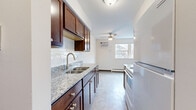 Located at 3529 18th Ave S in Minneapolis, MN, this single-floor, 3-bedroom, 1-bathroom unit offers a practical and well-appointed layout. The galley-style kitchen is a standout feature, showcasing rich dark wood cabinetry, granite countertops, a classic subway tile backsplash, and tile flooring. A ceiling fan and window at the end of the kitchen bring in natural light and airflow, while a full suite of appliances completes the space. The kitchen opens into a combined living and dining area, where tile flooring transitions to carpet, and a ceiling fan adds comfort overhead. The three bedrooms are carpeted and neutrally finished, each offering a clean, move-in ready feel. Select bedrooms include sliding closet doors, while additional storage is provided by a dedicated walk-in closet with dual shelving rods on each side. The bathroom features a full tub-shower combination surrounded by bright white subway tile, paired with chrome fixtures for a crisp, clean aesthetic. Throughout the unit, warm wood-toned doors and trim add a cohesive design element. This unit combines updated finishes with a straightforward, functional floor plan suited for comfortable everyday living.