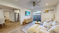 Located at 17249 N 7th St in Phoenix, AZ, this single-story 3-bedroom, 1-bathroom home offers a thoughtfully designed layout with modern finishes and a bright, cohesive aesthetic. Light-toned luxury vinyl plank flooring runs throughout, complementing the crisp white walls and recessed lighting that create a clean, airy atmosphere.

The living area serves as the heart of the home, featuring a ceiling fan, a wall-mounted TV, and sliding glass doors that invite natural light and provide access to the outdoors. The galley-style kitchen is efficiently designed with white shaker cabinetry, stone-finish countertops, a white tile backsplash, and a full suite of stainless steel appliances. A dedicated dining nook accommodates intimate meals with ease.

The spacious primary bedroom includes a ceiling fan, a sliding barn-style closet door revealing a generous walk-in closet, and light-filled windows with vertical blinds. The additional bedrooms are well-proportioned with closet access. The shared bathroom features a tub-shower combination with clean white surround finishes and wood-look flooring. A connecting hallway ties the rooms together efficiently. This home delivers a modern, move-in-ready experience in a convenient Phoenix location.