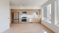 Located at 3585 Aero Ct, Unit 575 in San Diego, California, this efficiently designed one-bedroom, one-bathroom residence offers a clean, modern aesthetic throughout its single floor. Light wood-look flooring flows seamlessly across the space, complemented by crisp white walls and recessed lighting that create a bright, airy atmosphere.

The open-concept living area integrates the kitchen, dining, and living spaces into one cohesive layout. The kitchen is a standout feature, showcasing light wood cabinetry with brushed gold hardware, white quartz countertops, a tiled backsplash, and a full suite of stainless steel appliances including a gas range, built-in microwave, dishwasher, and a large French door refrigerator. Natural light pours in through well-positioned windows, enhancing the inviting feel of the shared living space.

A wide hallway connects the main living area to the private quarters, with access to a dedicated laundry space and a closet for additional storage. The bathroom features a warm wood vanity with a white countertop, a backlit mirror, and a clean, minimalist design with neutral tiling. The bedroom is an intimate, quiet retreat with the same light flooring and neutral palette. The unit's contemporary design and thoughtful layout make efficient use of its footprint throughout.