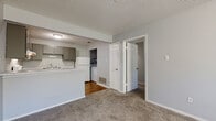 Located on Chenal Parkway in Little Rock, Arkansas, this single-floor unit offers a practical and well-organized layout designed for comfortable everyday living. The open living area features soft carpeting, neutral gray walls, and a ceiling fan with integrated lighting, creating a bright and airy atmosphere. Natural light filters in through windows fitted with blinds, adding warmth to the space. The kitchen is efficiently designed with gray cabinetry, light granite-style countertops, hardwood-style flooring, and white appliances including an electric range, dishwasher, and refrigerator. A kitchen peninsula separates the cooking area from the living space, offering a functional transition between the two zones. The bedroom is generously sized with plush carpeting, a large window for natural light, and direct access to a spacious walk-in closet equipped with wire shelving for ample storage. The full bathroom features tile flooring, a granite-top vanity with gray cabinetry, a full tub-shower combination, and grab bars for added accessibility. Textured ceilings throughout the unit complement the clean, neutral color palette, providing a cohesive and move-in-ready living environment.